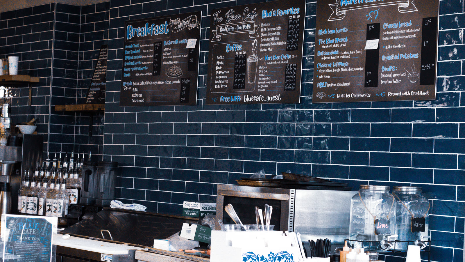 The Blue Cafe counter and handwritten menu boards against the blue tile wall.