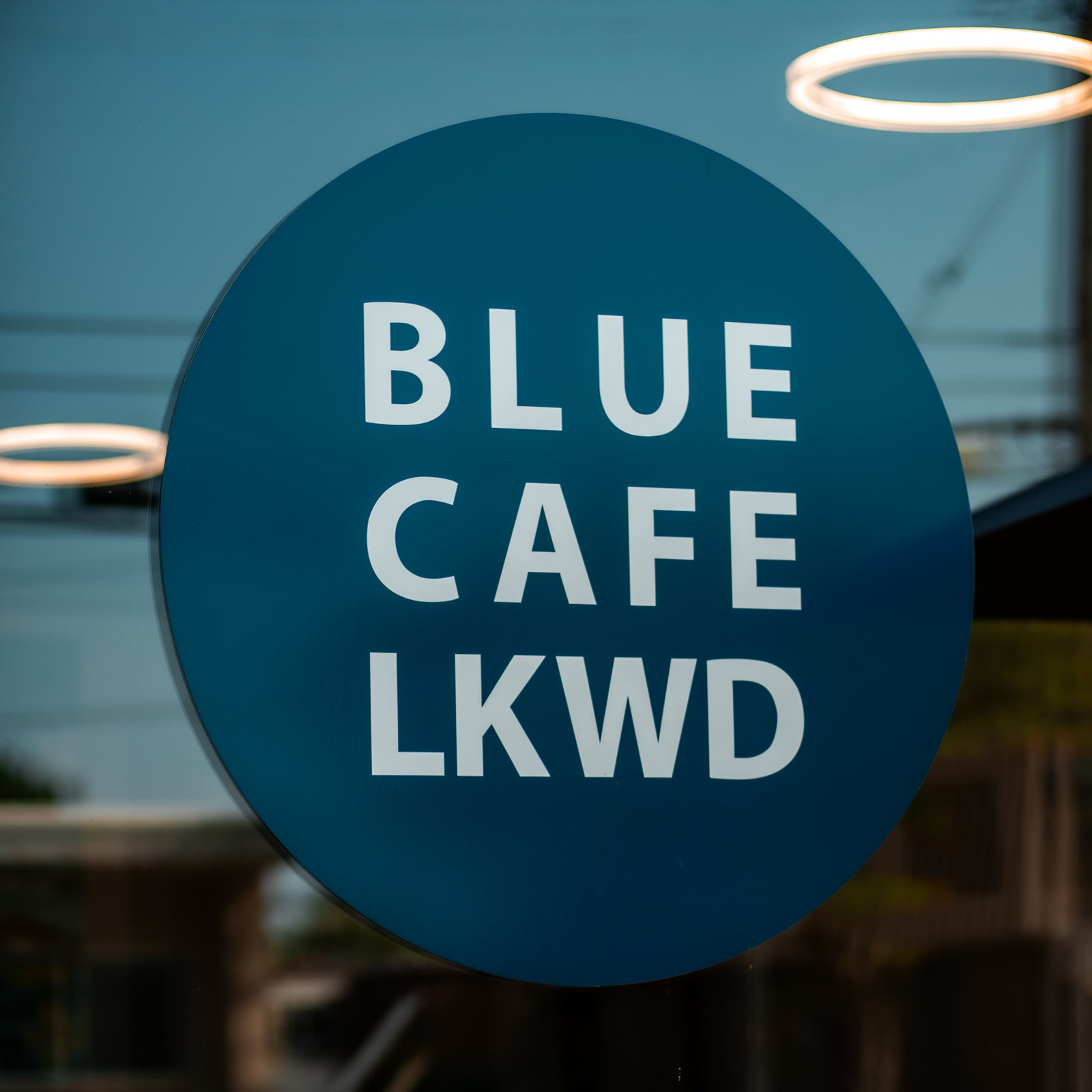 The round Blue Cafe LKWD sign on the front window.