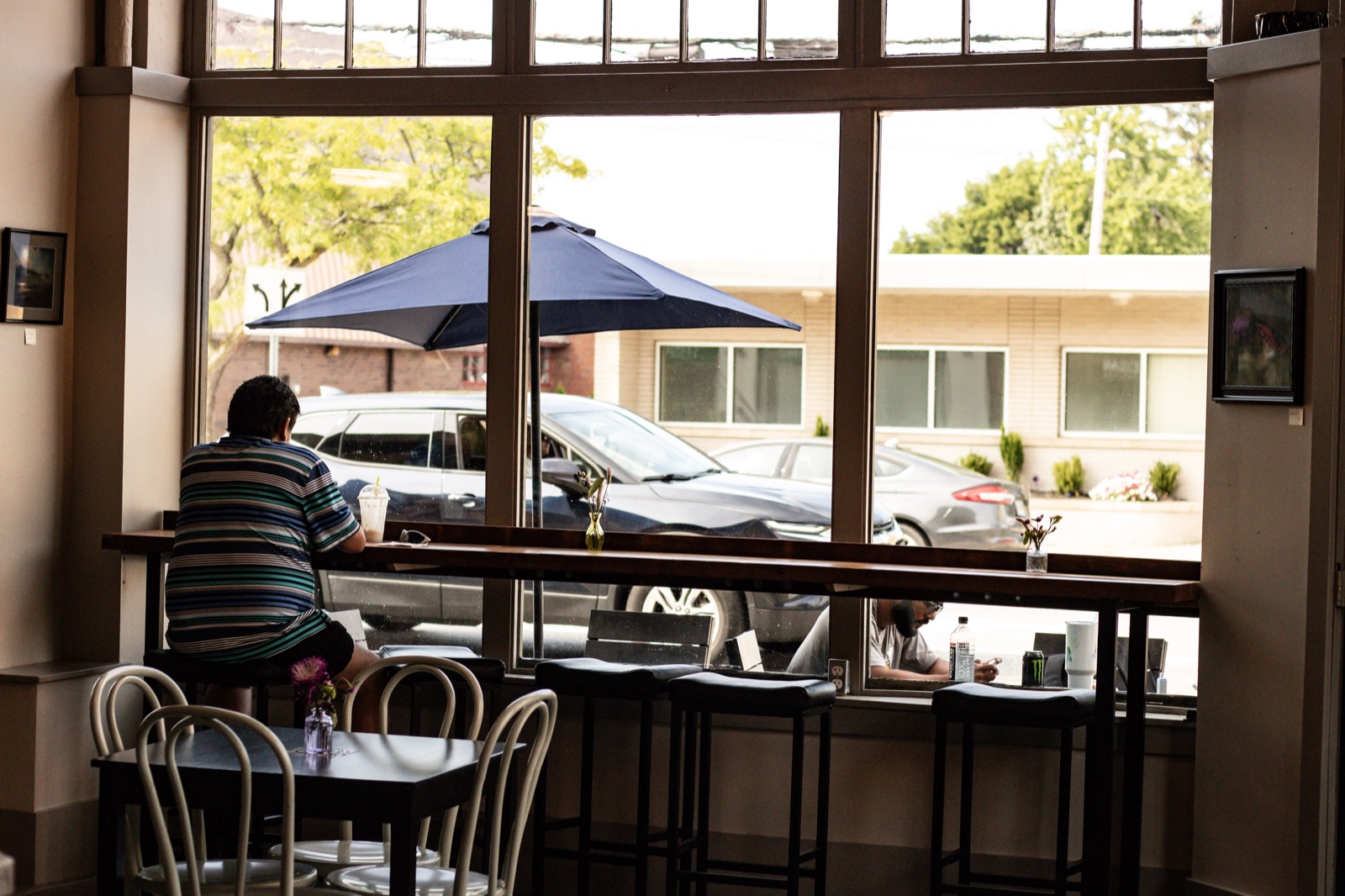 A customer seated at the window counter inside the Blue Café.